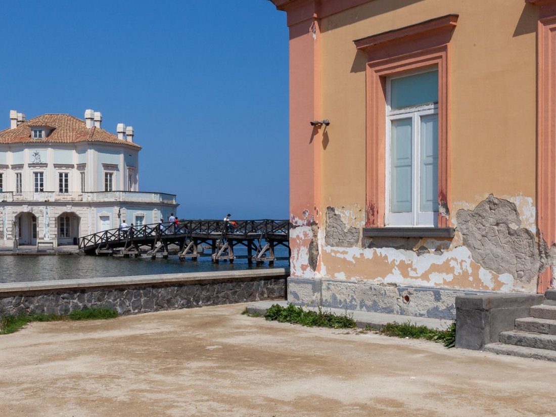 Il padiglione della Casina Vanvitelliana visto attraverso il Lago Fusaro a Bacoli accanto a un edificio di epoca borbonica