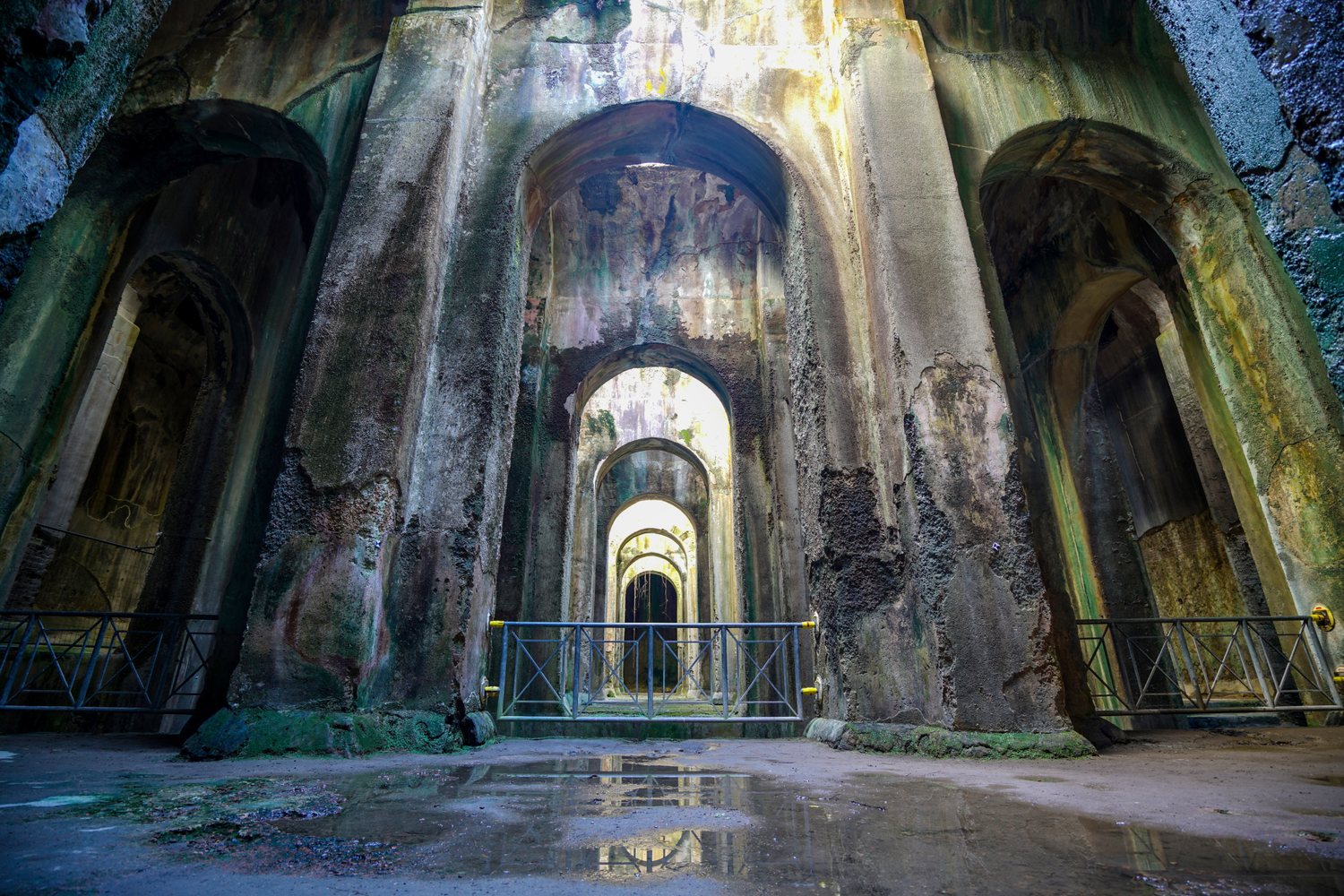 All'interno della Piscina Mirabilis di Bacoli — la vasta cisterna romana con pilastri imponenti e navate ad arco che un tempo riforniva la flotta imperiale di Miseno