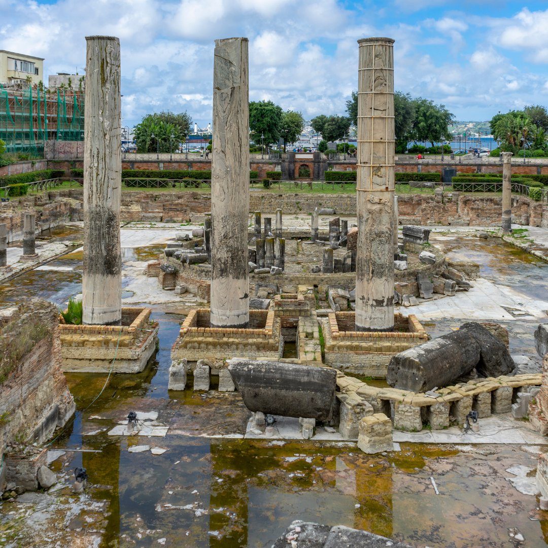 Tre alte colonne di marmo del Macellum, il cosiddetto Tempio di Serapide, che si ergono dall'antico mercato romano allagato di Pozzuoli